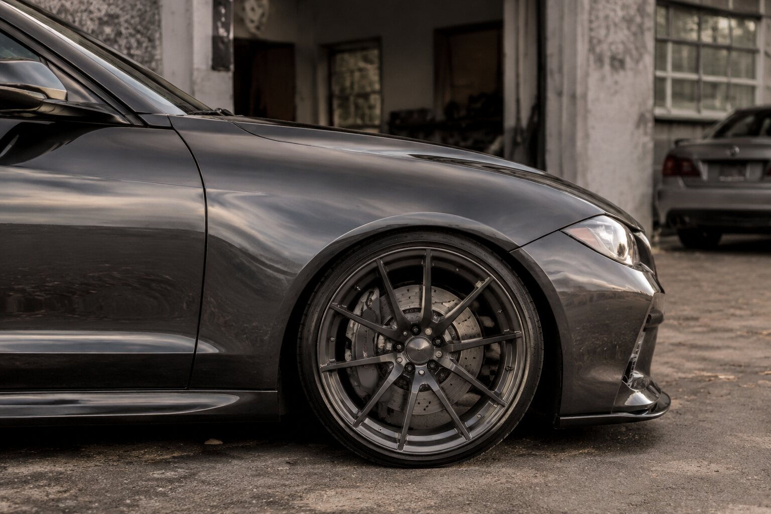 Detailed view of a graphite car's wheel, tire, brake and stance